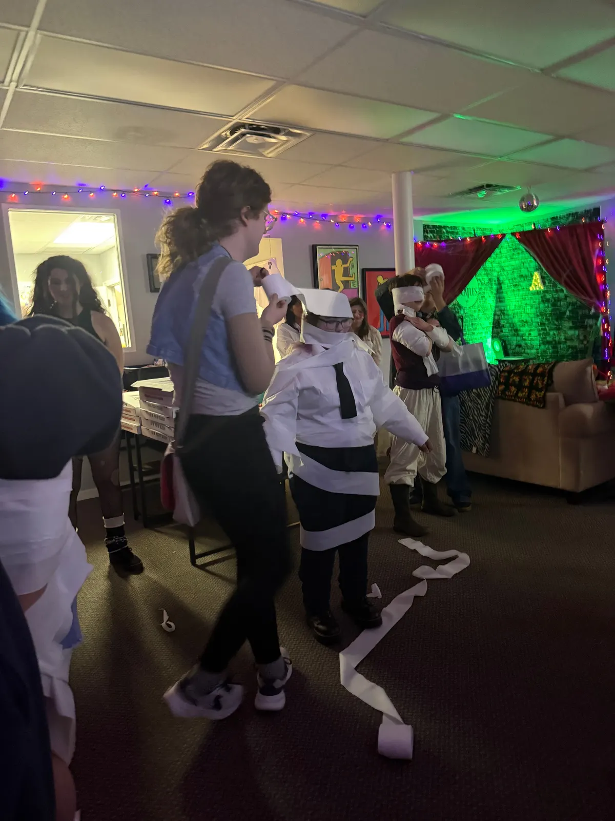 The mummy wrap game at Halloween in the Sarasota Center lounge, with streamers of toilet paper across the floor.
