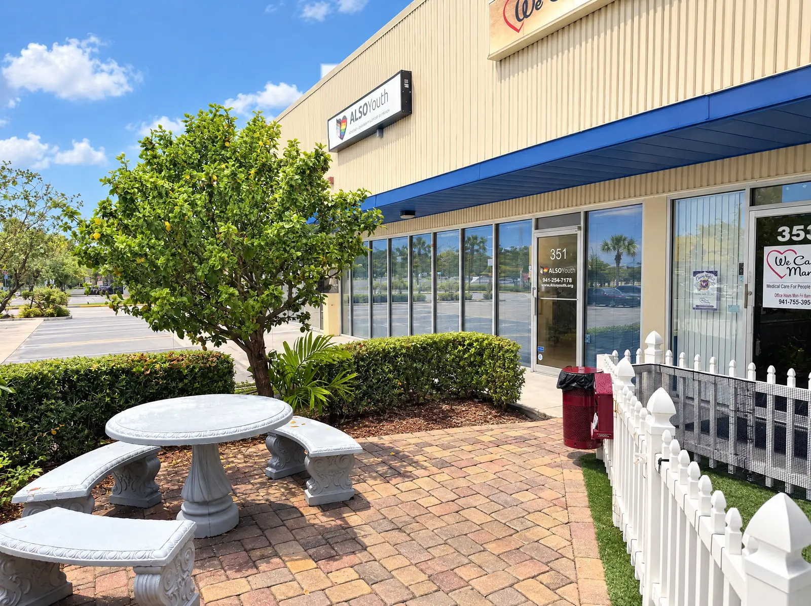 The Bradenton Center at 351 6th Avenue West: a tan building with a blue awning and an ALSO Youth sign, and a patio with a stone table and benches.