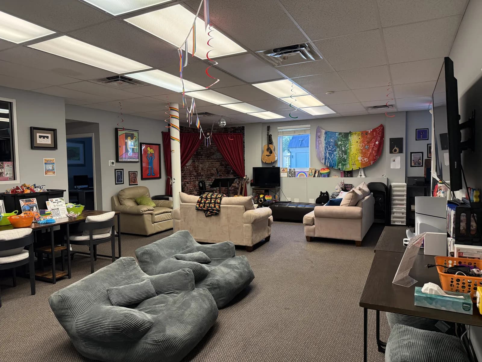 A wide view of the Sarasota Center lounge, with bean bags in front, couches in the back, and a table of snacks to one side.